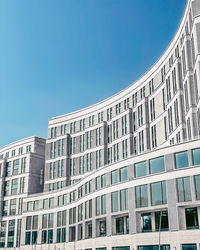 Low angle view of modern building against blue sky