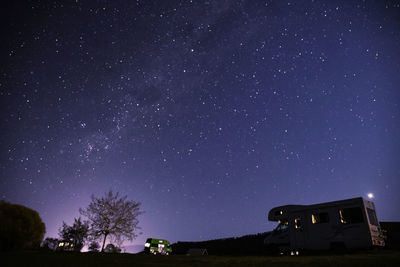 Low angle view of trees against star field at night