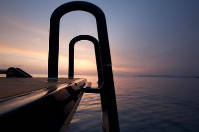 Scenic view of sea seen through ladder of boat against sky during sunset