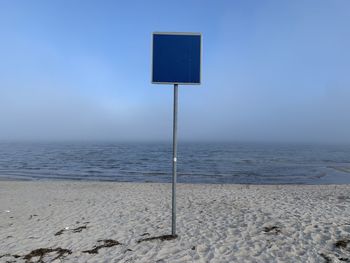 Scenic view of empty shield at beach against sea and clear sky