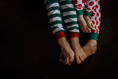 Low section of family in pajamas against black background