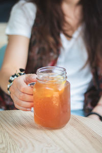 Close-up of woman holding drink on table