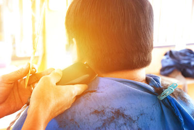 Rear view of man getting haircut at barber shop