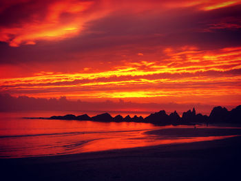 Scenic view of sea against dramatic sky during sunset