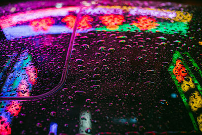 High angle view of water drops on multi colored glass