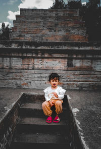 Portrait of young woman sitting on staircase