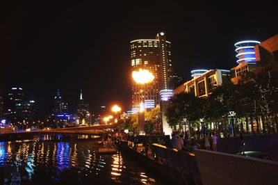 Illuminated city against clear sky at night