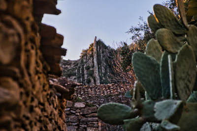 Low angle view of old ruin amidst buildings against sky