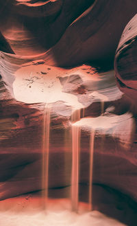 Digital composite image of rock formation in water at sunset