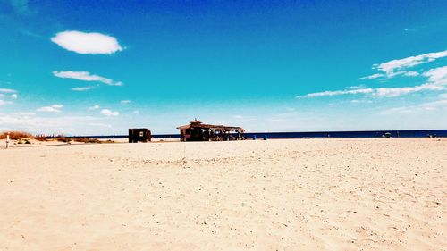 Scenic view of beach against cloudy sky