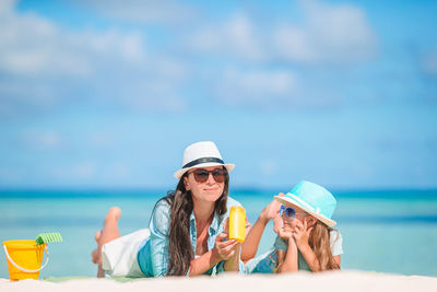 Portrait of woman by sunglasses against sea