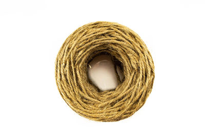 Directly above of rolled up rope over white background