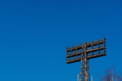 Low angle view of communications tower against clear blue sky