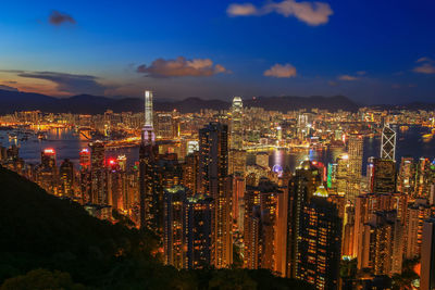 Illuminated modern buildings in city against sky