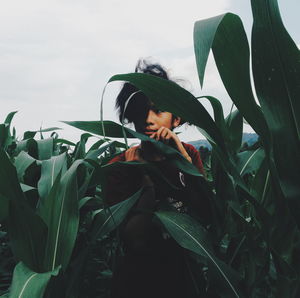 Man hiding amidst crops on field