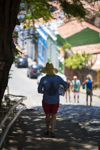 Rear view of man walking on footpath