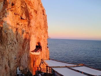 Scenic view of rock formation in sea against clear sky