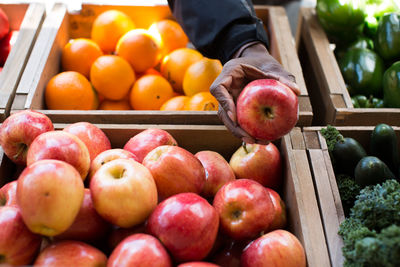 Cropped image of hand holding apple at market stall