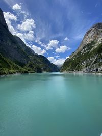 Scenic view of lake by mountains against sky