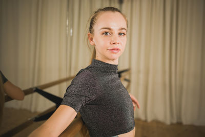 Portrait of young woman standing at home