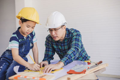 Engineer assisting son in making drawing