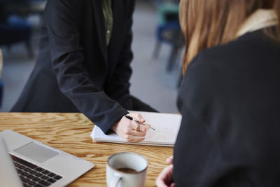 Mid section of woman sitting in office