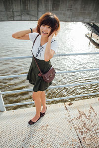 Portrait of smiling young woman standing in water