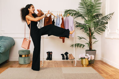 Cheerful woman gesturing while standing at home