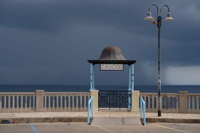 Street light by sea against sky