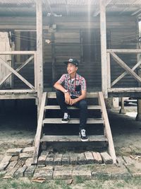 Portrait of young man sitting on wood