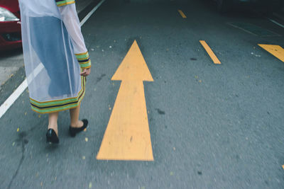 Low section of woman in costume walking on road