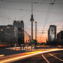 Light trails on city street against sky