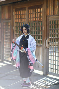 Portrait of young woman standing in city