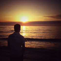 Rear view of silhouette man standing on beach