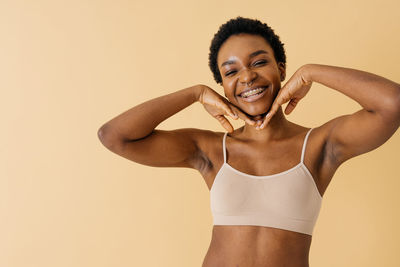 Portrait of young woman against pink background