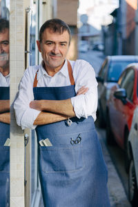 Portrait of a middle-aged hairdresser posing on the street.