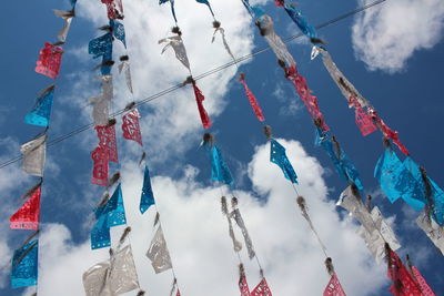 Low angle view of buntings hanging against sky