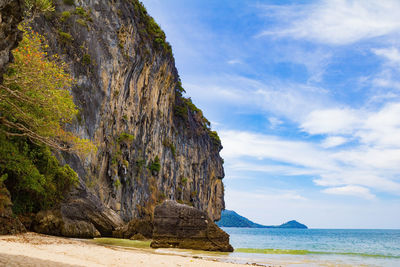 Rock formation on sea shore against sky