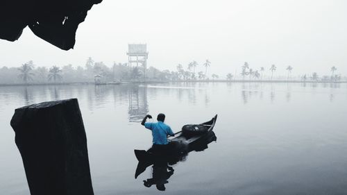 Men in lake against sky