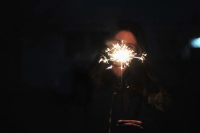 Close-up of hand holding sparkler at night