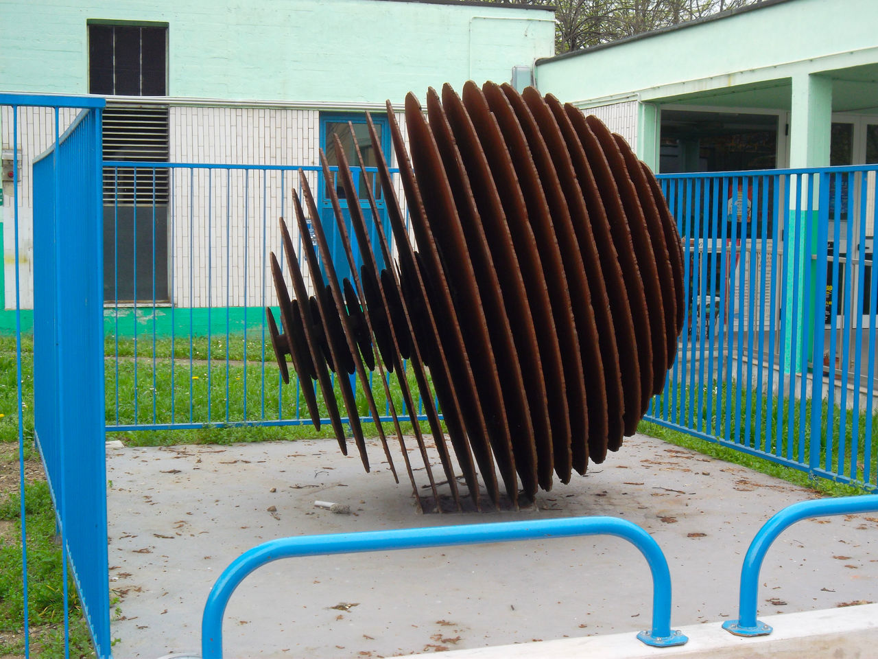 CLOSE-UP OF METALLIC FENCE AGAINST BUILDING