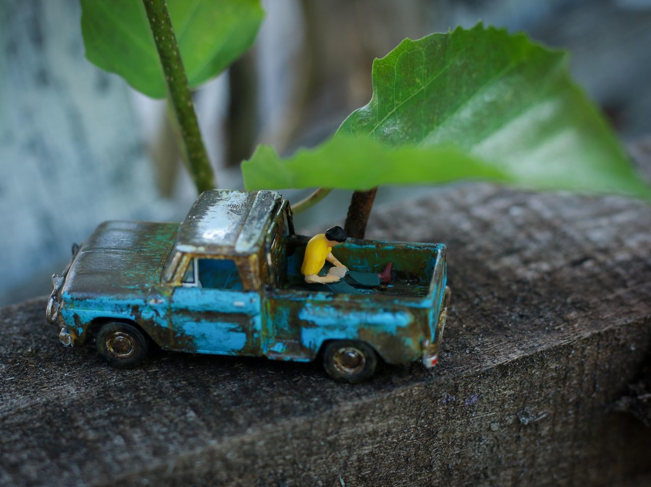 HIGH ANGLE VIEW OF TOY CAR ON WOOD