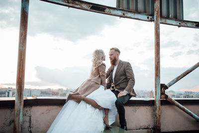 Rear view of couple standing against sky