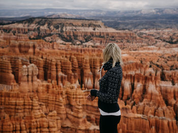 Rear view of woman standing in cave