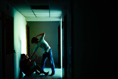 Side view of man standing at entrance of building