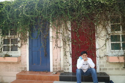 Full length of a man sitting on wall