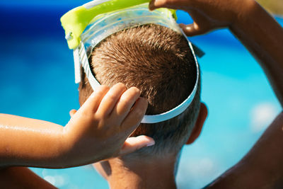 Rear view of boy wearing swimming goggles