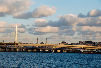 Bridge over river in city against sky