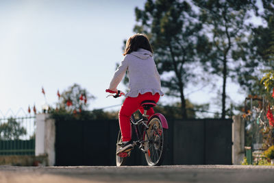 Rear view of woman riding bicycle on street