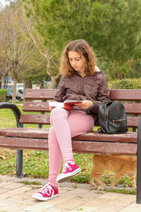 Woman sitting on bench in park